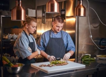 male-chef-with-assistant-standing-in-a-kitchen-pre-PCVW5CR.jpg